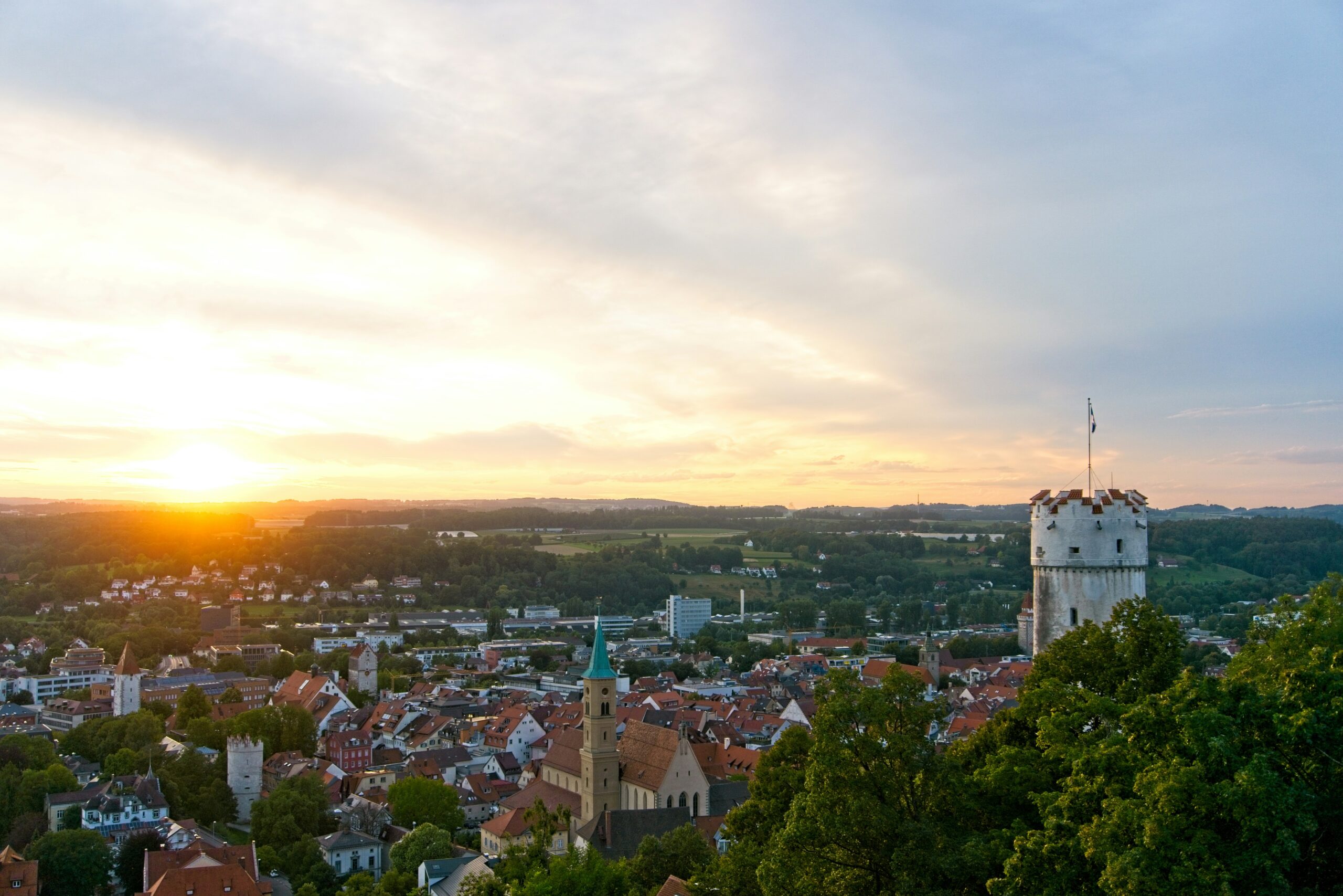 Die Sonne geht über der Skyline der Stadt Ravensburg auf.